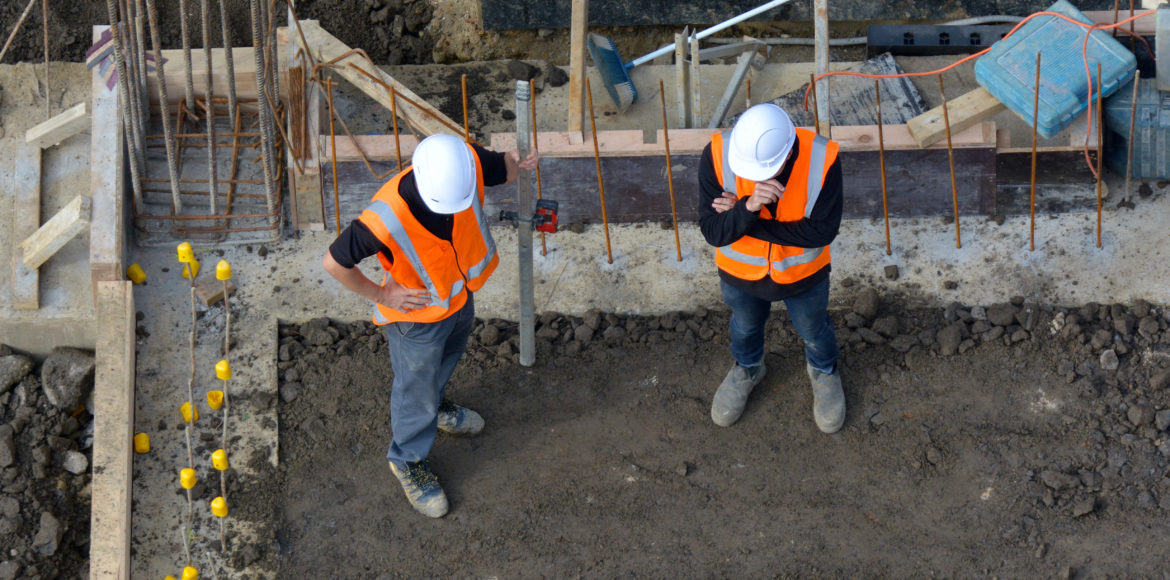 Aerial view of two unrecognised civil engineers inspecting the work progress in a construction site. Building development concept with copy space